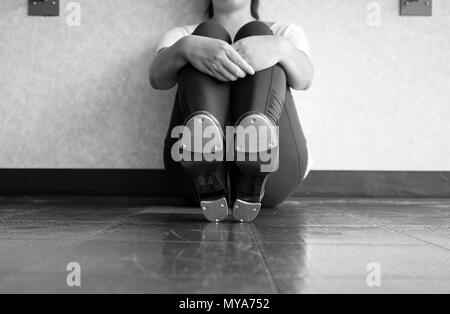 Schwarze und weiße Version von Tap dancer Sitzen, die Hähne, und halten ihre Beine Stockfoto