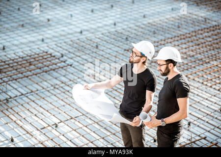 Maschinenbauer mit Zeichnungen auf der Baustelle Stockfoto