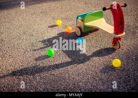 Stilvolle vintage Holz- bunte Fahrrad und viele kleine Kugeln auf dem Asphalt, im Freien Unterhaltung für Kinder, glückliche Kindheit Konzept Stockfoto