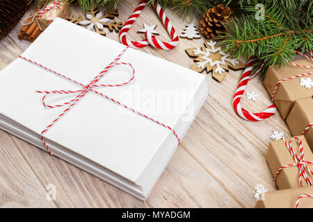 Umschlag mit leeren Blatt Papier auf Weihnachten Hintergrund-fir Zweig, Tannenzapfen, red ribbon, Sterne und Herzen von Süßigkeiten. Platz für Ihren Text. Stockfoto