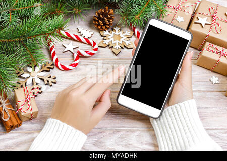 Weibliche Käufer macht, um auf den Bildschirm des Smartphones mit kopieren. Weihnachten online einkaufen. Frau kauft Geschenke für Weihnachten. Winterurlaub Vertrieb. Stockfoto