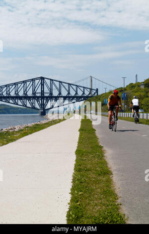 Radfahrer auf der Promenade Samuel de Champlain Radweg in Quebec, mit der St. Lawrence River in Pont du Quebec Brücke jenseits Stockfoto