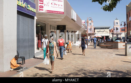 WINDHOEK Namibia - 10. MAI 2018; Menschen in der Afrikanischen Stadt Straße Geschäfte und Bettler vorbei gehen. Stockfoto