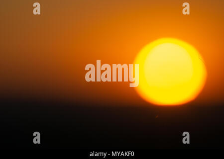 Goilden Sky von großen runden untergehende Sonne am Ende des Tages in Namibia beleuchtet. Stockfoto