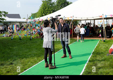 Ansicht der Rückseite des jungen Frau Dreharbeiten @ BBCclick presenter Spencer Kelly am Hay Festival Website im Sonnenschein im Mai 2018 Hay-on-Wye Wales UK KATHY DEWITT Stockfoto