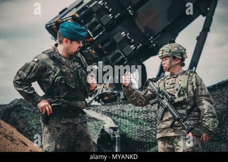 Cpt, 4. Juni 2018. Grzegorz Piskiewcz, die Luftverteidigung Officer, 12 Mechanisierte Division Headquarters und Sgt. 1. Klasse Paige Shelton vom 5 Battalion, 7th Air Defense Artillery Regiment, in der Drawsko Pomorskie, Polen einige der Fähigkeiten des neuen US-Armee Patriot missile Systems zu erörtern, 4. Juni 2018. Erziehen unsere Verbündeten auf unserer Verteidigung Strategien und Waffensysteme schafft Vertrauen unter unseren multinationalen Partnern auf der ganzen Welt. (Michigan Army National Guard Foto von SPC. Aaron Gut/Freigegeben). () Stockfoto