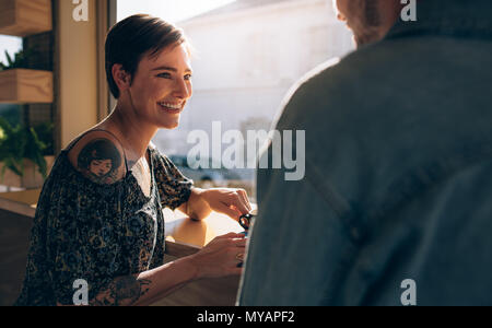 Schöne Frau in einem Café sitzen mit ihrem Freund. Lächelnden jungen Paar an der Coffee Shop. Stockfoto