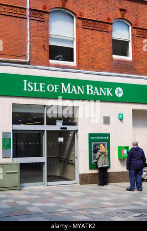 Menschen mit einem Geldautomaten Geldautomaten außerhalb der Insel Man Bank Filiale in Douglas, Isle of Man, Britische Inseln Stockfoto