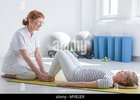 Weiblichen Physiotherapeuten arbeiten mit Kind in hellen Arbeits Zimmer Stockfoto