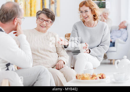 Senior glücklich, Frauen und älteren Menschen klatschen bei einer Tea Party Stockfoto