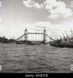 1960er Jahre, historischer Blick über die Themse auf die berühmte Tower Bridge der Stadt, die Kraniche am Flussufer auf der rechten Seite des Bildes zeigt. In dieser Zeit begann sich das Flussufer der Themse zu entwickeln. Stockfoto