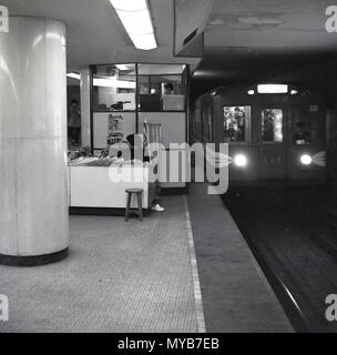 Ende der 1950er Jahre, historische, Bild aus Tokio U-Bahn Zug in eine Station, auf der Plattform eine weibliche Zeitschrift und Zeitung Verkäufer in Ihrem kleinen Kiosk, Tokio, Japan. Der Tokioter U-Bahn eröffnet im Jahre 1927. Stockfoto