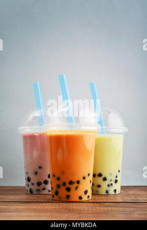 Verschiedene Bubble Tea in einem Plastikbecher mit Getränk Strohhalme auf blauem Hintergrund. Nehmen Getränke Konzept. Stockfoto