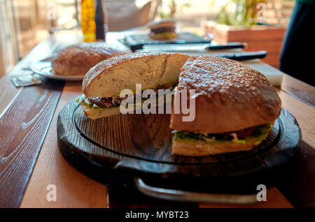 Große saftige Burger auf dem Tisch Stockfoto