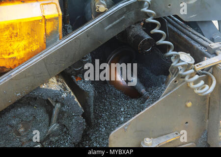 Anwendung der neuen heißen Asphalt mit Straßenbaumaschinen und Power industrial Tools. Baustellen belagserneuerung Prozess. Stockfoto