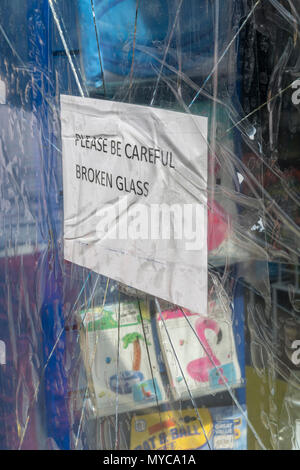 Shattered Glas Schaufenster in Truro, Cornwall. Glas von Vandalen beschädigt. Vandalismus Metapher. Stockfoto