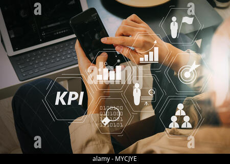 Key Performance Indicator (KPI) workinng mit Business Intelligence (BI) Metriken erreichen und geplante Ziel zu messen. Hand mit Smart Phone und Stockfoto