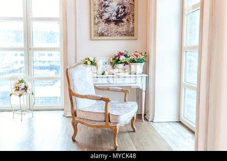 Schönen Luxus klassische weiße helle saubere Inneneinrichtung Schlafzimmer im barocken Stil mit großem Fenster, Sessel und Blume Zusammensetzung Stockfoto