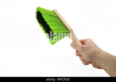 Hand hält eine grüne Staub Besen auf weißem Hintergrund Stockfoto