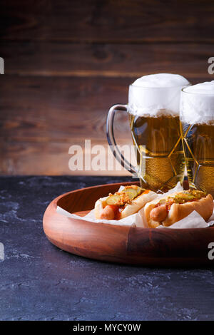 Foto von zwei Gläser Bier und Hot Dogs auf Holz Fach Stockfoto