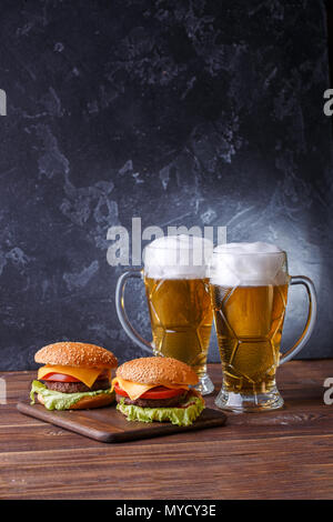 Foto von zwei Hamburger, Gläser mit Bier Stockfoto