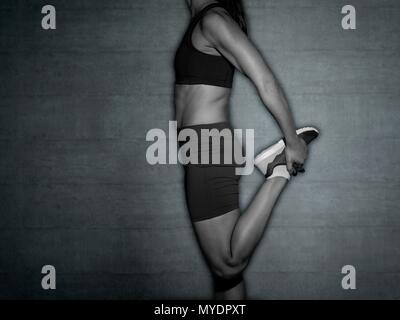 Junge Frau stretching Bein, 7/8 Schuß. Stockfoto