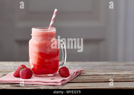 Joghurt und Erdbeere Smoothie in Glas auf hölzernen Tisch Stockfoto