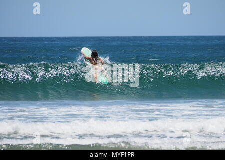 Frau Surfen in Playa Hermosa, an der Pazifikküste von Nicaragua. Stockfoto