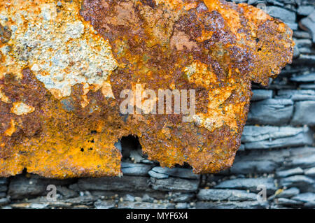 Sehr rostiges Metall auf einem grauen zerbrochene Fels, helles Sonnenlicht, in der Nähe Stockfoto