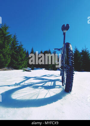 Mountainbike im Schnee, Sonne, blauen Himmel. Winter Fahrrad Ausbeutung in den Bergen Stockfoto