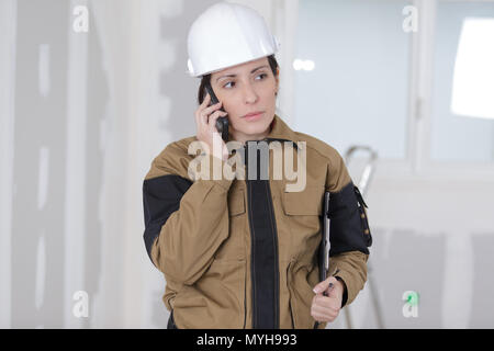 Pretty Woman Arbeiter auf dem Telefon auf der Baustelle Stockfoto