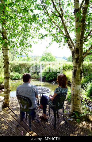 Die Besucher der offenen Gärten bei Newton Valence Entspannung am Teich Cottage, Newton Valence, in der Nähe von Alton, Hampshire, UK. 20.05.2018. Stockfoto