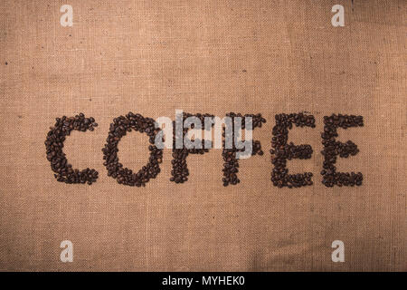 Kaffee Wort mit gerösteten Kaffeebohnen auf Draufsicht Zusammensetzung geschrieben Stockfoto