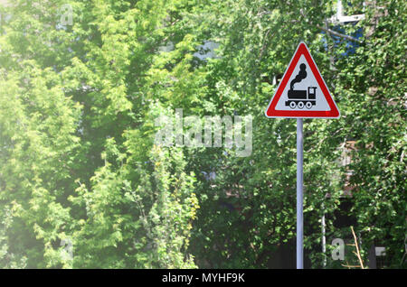 Dreieckiges Verkehrsschild mit dem Bild eines schwarzen Lokomotive auf weißem Hintergrund in einem roten Rahmen. Warnzeichen für die Anwesenheit von einem Bahnübergang. Stockfoto