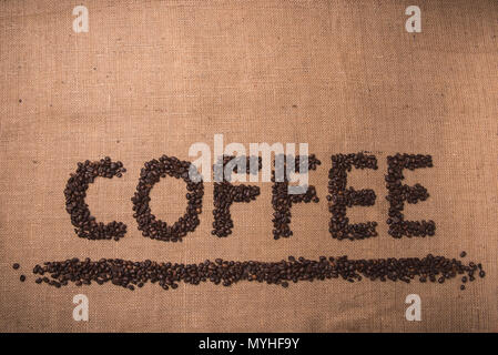 Kaffee Wort mit gerösteten Kaffeebohnen auf Draufsicht Zusammensetzung geschrieben Stockfoto