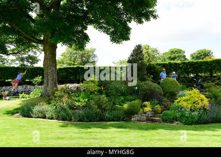 Die Besucher der offenen Gärten bei Newton Valence durchlesen ein Englischer Garten im Innenhof, Newton Valence, in der Nähe von Alton, Hampshire, UK. 20.05.2018. Stockfoto