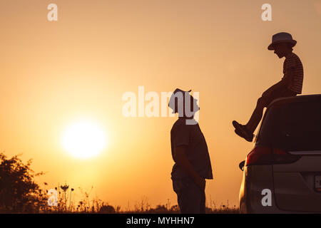 Vater und Sohn spielen im Park bei Sonnenuntergang. Leute, die Spaß auf dem Feld. Konzept der freundliche Familie und der Sommerferien. Stockfoto