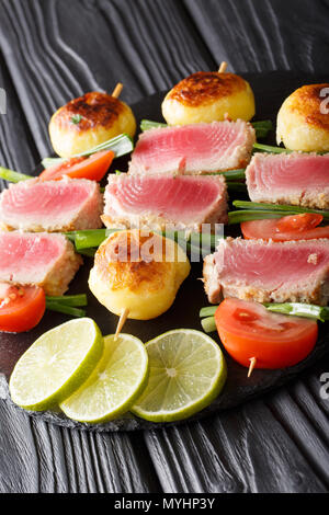 Kebab von Thunfisch, Tomaten, Kartoffeln und grüne Zwiebeln close-up auf einem Tisch. Vertikale Stockfoto