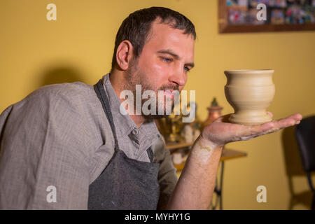 Professionelle männlichen potter Prüfung Steingut Becher in Töpferei, Studio. Handwerk, Kunst und Handarbeit Konzept Stockfoto