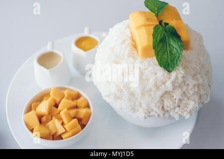 Bingsu Mango (Koreanische Desserts) rasiert Eis Desserts mit Mango auf der Oberseite und gesüßte Kondensmilch und kondensierten mango Saft. Stockfoto
