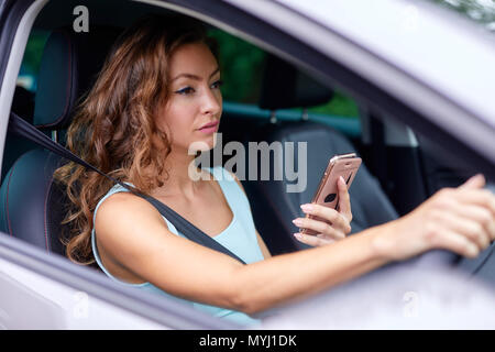 Frau, die zwar mit Handy Stockfoto