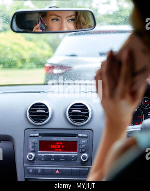 Frau, die zwar mit Handy Stockfoto