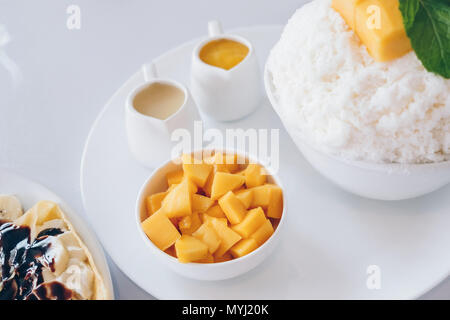 Bingsu Mango (Koreanische Desserts) rasiert Eis Desserts mit Mango auf der Oberseite und gesüßte Kondensmilch, Banane kalten Krepp (japanische Desserts), Crepe mit c Stockfoto