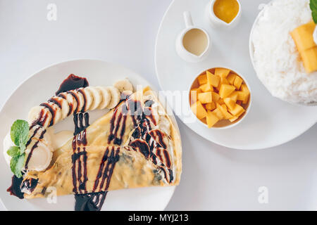 Bingsu Mango (Koreanische Desserts) rasiert Eis Desserts mit Mango auf der Oberseite und gesüßte Kondensmilch, Banane kalten Krepp (japanische Desserts), Crepe mit c Stockfoto