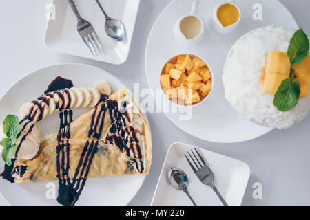 Bingsu Mango (Koreanische Desserts) rasiert Eis Desserts mit Mango auf der Oberseite und gesüßte Kondensmilch, Banane kalten Krepp (japanische Desserts), Crepe mit c Stockfoto