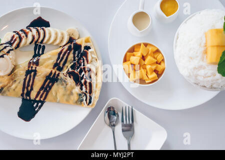 Bingsu Mango (Koreanische Desserts) rasiert Eis Desserts mit Mango auf der Oberseite und gesüßte Kondensmilch, Banane kalten Krepp (japanische Desserts), Crepe mit c Stockfoto