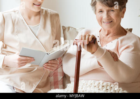 Close-up von lächelnden älteren Frau mit Stock und freundlichen Krankenschwester Stockfoto