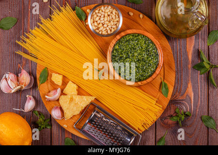 Grüne Basilikum Pesto - italienisches Rezept Zutaten auf Holztisch, Ansicht von oben. Stockfoto