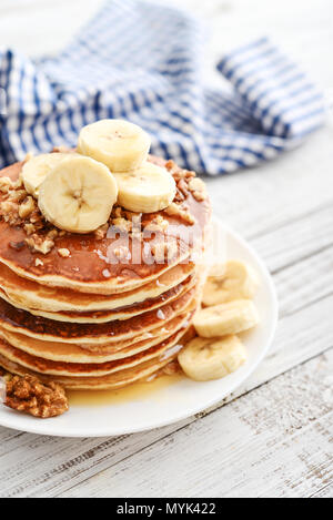 Pfannkuchen mit Banane, Nussbaum und muple Sirup für ein Frühstück auf hölzernen Hintergrund closeup Stockfoto