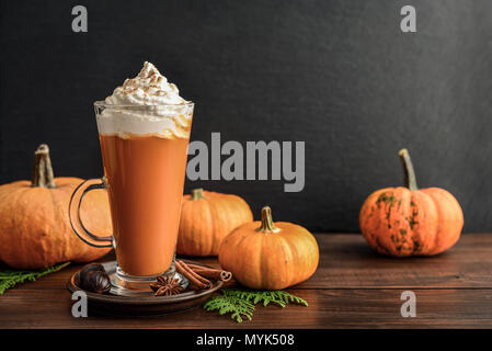 Pumpkin spice Latte mit Schlagsahne auf hölzernen Hintergrund Stockfoto